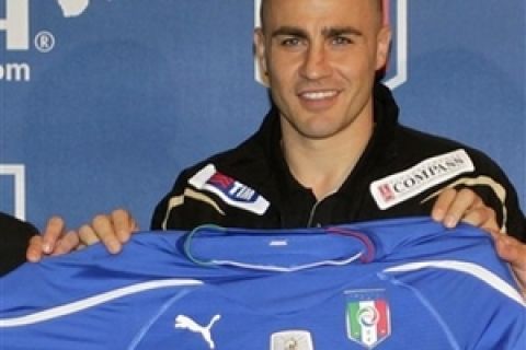 Italian national soccer team captain Fabio Cannavaro smiles as he shows the new team jersey during a press conference at the Coverciano training grounds, near Florence, central Italy, Monday March 1, 2010. Soccer World Cup winner in 2006, Italy will play a friendly match  against Cameroon in Monte Carlo, Wednesday March 3, 2010. (AP Photo/Lorenzo Galassi)