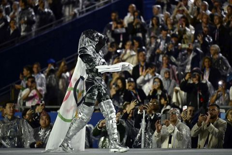 Floriane Issert, a non-commissioned officer for the National Gendarmerie, carries the Olympic flag into the Trocadero during the opening ceremony for the 2024 Summer Olympics in Paris, France, Friday, July 26, 2024. (Loic Venance/Pool Photo via AP)