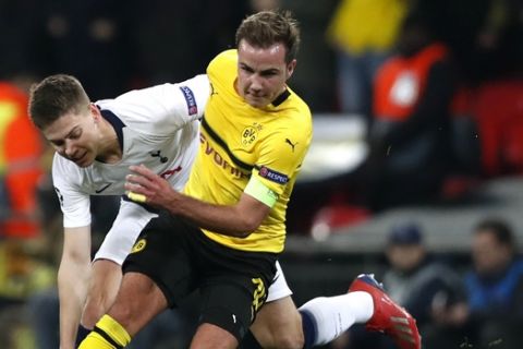 Tottenham defender Juan Foyth fights for the ball with Dortmund midfielder Mario Gotze, right, during the Champions League round of 16, first leg, soccer match between Tottenham Hotspur and Borussia Dortmund at Wembley stadium in London, Wednesday, Feb. 13, 2019. (AP Photo/Alastair Grant)