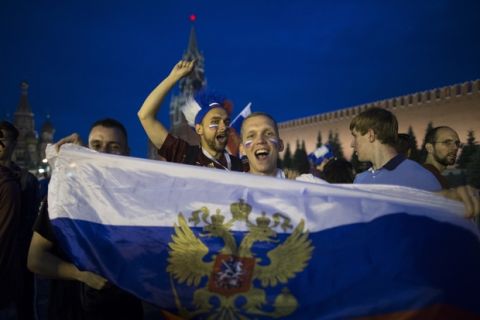 Russia soccer fans celebrate their team victory against Spain in Red Square after the round of 16 match between Spain and Russia at the 2018 soccer World Cup at the Luzhniki Stadium in Moscow, Russia, Sunday, July 1, 2018. Russia shocks Spain at the World Cup, beating the 2010 champion 4-3 in a penalty shootout after a 1-1 draw. (AP Photo/Alexander Zemlianichenko)