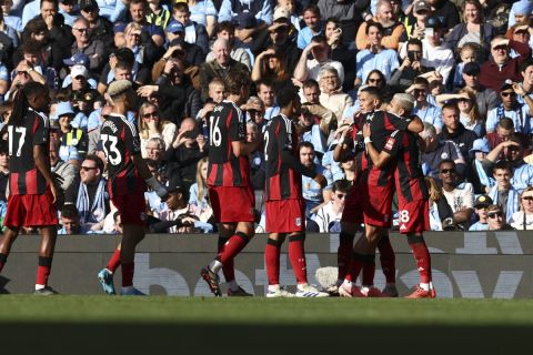 Fulham's Andreas Pereira, right, celebrates with teammates after scoring the opening goal during the English Premier League soccer match between Manchester City and Fulham at Etihad Stadium in Manchester, England, Saturday, Oct. 5, 2023. (AP Photo/Darren Staples)