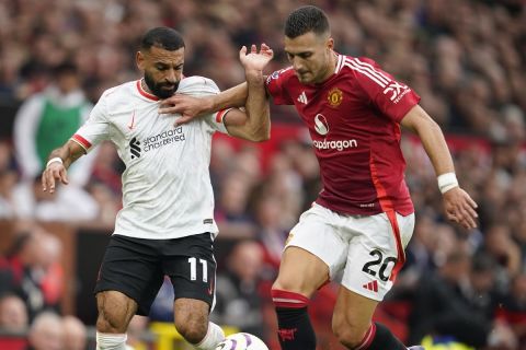 Liverpool's Mohamed Salah, left, challenges for the ball with Manchester United's Diogo Dalot during the English Premier League soccer match between Manchester United and Liverpool at Old Trafford, Sunday, Sept. 1, 2024, in Manchester, England. (AP Photo/Dave Thompson)