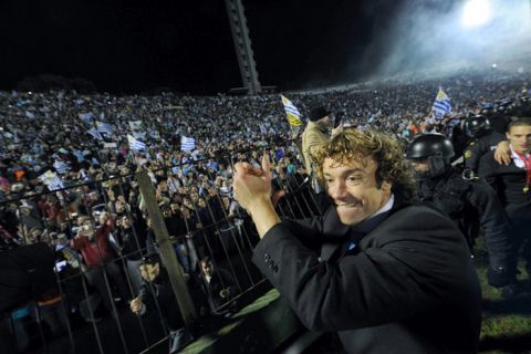 Uruguay's captain Diego Lugano (R) waves to supporters at the Centenario stadium in Montevideo on July 25, 2011, after his team won the Copa America tournament. Uruguay defeated Paraguay 3-0 on July 24 to win a record 15th Copa America with striker Diego Forlan grabbing two goals to take his international tally to 31 and complete an incredible family story. AFP PHOTO / PABLO PORCIUNCULA (Photo credit should read PABLO PORCIUNCULA/AFP/Getty Images)