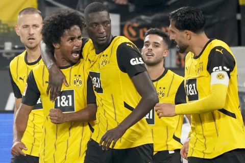 Dortmund's Serhou Yadaly Guirassi, center, celebrates with Karim Adeyemi, 2nd left, and Emre Can, right, after scoring his side's third goal during the German Bundesliga soccer match between Borussia Dortmund and VfL Bochum at Westfalenstadion in Dortmund, Germany, Friday, Sept. 27, 2024. (AP PhotoMartin Meissner)