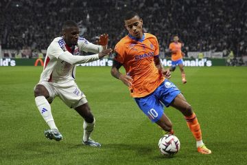 Marseille's Mason Greenwood, right, challenges Lyon's Clinton Mata  for the ball during a French League One soccer match at the Groupama stadium in Decines, outside Lyon, France, Sunday, Sept. 22, 2024. (AP Photo/Laurent Cipriani)