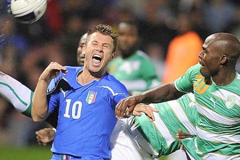 Italy's Antonio Cassano, left, reacts as he vies for the ball with Ivory Coast's Guy Demel, right, during their International Friendly soccer match at West Ham's Upton Park Stadium in London, Tuesday, Aug. 10, 2010. (AP Photo/Tom Hevezi)