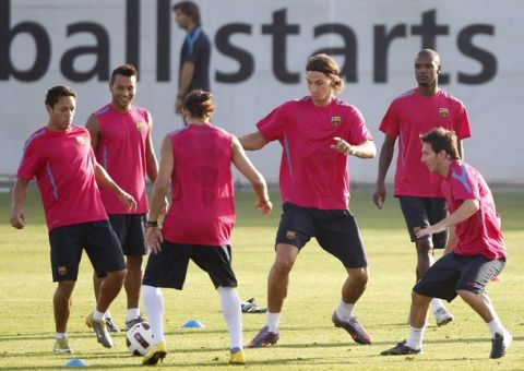 Barcelona's Zlatan Ibrahimovic (3rd R), Lionel Messi (R) and their teammates take part in a training session at Joan Gamper training camp, near Barcelona, August 27, 2010. Barca are still locked in negotiations with AC Milan to sell Swedish striker Ibrahimovic before the end of the transfer window. REUTERS/Albert Gea (SPAIN - Tags: SPORT SOCCER)