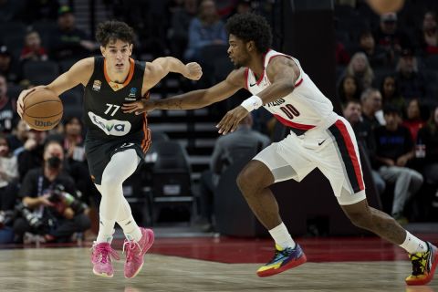 Ratiopharm Ulm guard Ben Saraf, left, dribbles past Portland Trail Blazers guard Scoot Henderson during the first half of a preseason NBA basketball game in Portland, Ore., Wednesday, Oct. 16, 2024. (AP Photo/Craig Mitchelldyer)