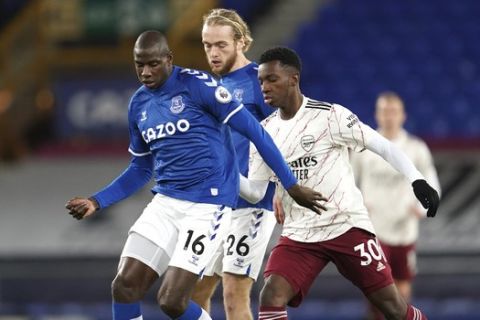 Everton's Abdoulaye Doucoure, left, duels for the ball with Arsenal's Eddie Nketiah during the English Premier League soccer match between Everton and Arsenal at Goodison Park in Liverpool, England, Saturday, Dec. 19, 2020. (AP Photo/Jon Super, Pool)