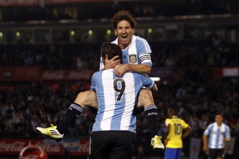 Argentina's Lionel Messi (top) celebrates with teammate Gonzalo Higuain after he scored a goal against Ecuador during a World Cup qualifying soccer match in Buenos Aires June 2, 2012.  REUTERS/Marcos Brindicci (ARGENTINA - Tags: SPORT SOCCER TPX IMAGES OF THE DAY)