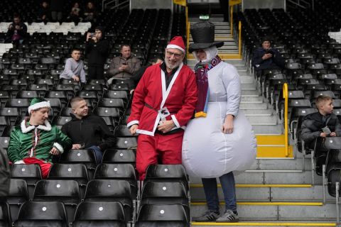 Burnley supporters take their seats on the stands ahead of the English Premier League soccer match between Fulham and Burnley at Craven Cottage stadium in London, Saturday, Dec. 23, 2023. (AP Photo/Alastair Grant)