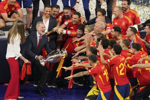 Spanish King Felipe VI holds the trophy as he and his daughter Princess Sofia celebrate with the players they won the final match between Spain and England at the Euro 2024 soccer tournament in Berlin, Germany, Sunday, July 14, 2024. (AP Photo/Andreea Alexandru)