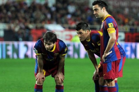 SEVILLE, SPAIN - MARCH 13:  Lionel Messi (L), David Villa (C) and Xavi Hernandez of Barcelona line up a free kick during the la Liga match between Sevilla and Barcelona at Estadio Ramon Sanchez Pizjuan on March 13, 2011 in Seville, Spain.  (Photo by Jasper Juinen/Getty Images)