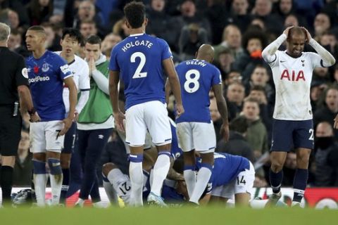 Everton players check on the condition of team-mate Andre Gomes following a challenge by Tottenham Hotspur's Son Heung-min, second left, during the English Premier League soccer match at Goodison Park, Liverpool, England, Sunday Nov. 3, 2019. (Nick Potts/PA via AP)