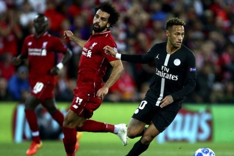 Liverpool's Mohamed Salah, left, competes for the ball with PSG's Neymar during the Champions League Group C soccer match between Liverpool and Paris-Saint-Germain at Anfield stadium in Liverpool, England, Tuesday, Sept. 18, 2018. (AP Photo/Dave Thompson)