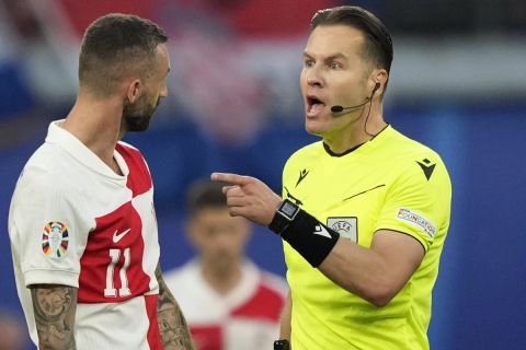 Referee Danny Makkelie, right, talks with Croatia's Marcelo Brozovic during a Group B match between Croatia and Italy at the Euro 2024 soccer tournament in Leipzig, Germany, Monday, June 24, 2024. (AP Photo/Ebrahim Noroozi)