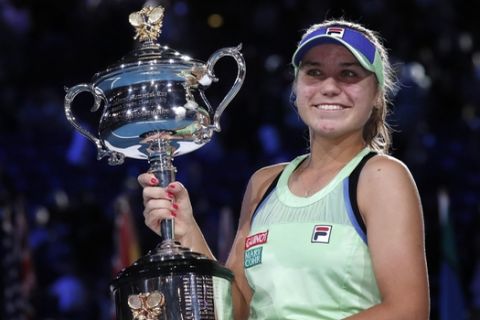 Sofia Kenin of the U.S. holds the Daphne Akhurst Memorial Cup aloft after defeating Spain's Garbine Muguruza in the womenÅfs singles final at the Australian Open tennis championship in Melbourne, Australia, Saturday, Feb. 1, 2020. (AP Photo/Lee Jin-man)