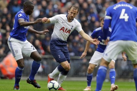 Tottenham's Harry Kane, center, is challenged by Cardiff City's Sol Bamba, left, during the English Premier League soccer match between Tottenham Hotspur and Cardiff City at Wembley stadium in London, Saturday, Oct. 6, 2018. (AP Photo/Kirsty Wigglesworth)