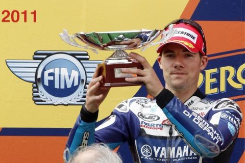 Yamaha MotoGP rider Ben Spies of the U.S. holds the trophy on the podium after his third position of the Catalunya MotoGP Grand Prix at the Montmelo race track, near Barcelona, June 5, 2011. Honda's Stoner of Australia won the race with Yamaha's Lorenzo of Spain in second and Spies in third. REUTERS/Gustau Nacarino(SPAIN - Tags: SPORT MOTOR RACING)