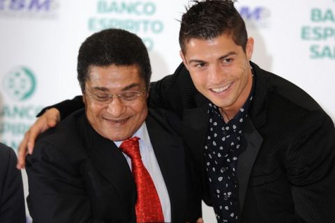 Real Madrid's Portuguese forward Cristiano Ronaldo (R) poses with Portuguese former soccer player Eusebio after receiving his "Golden Boot 2011" award, presented to Europes best goal scorer, on November 04 in Madrid 2011. Cristiano Ronaldo's 40 strikes in La Liga this season have given him the Golden Boot award for 2011. Cristiano is the first to earn 80 points in the run for the trophy and is the eighth player to win it twice, having previously taken it in 2008 as a Manchester United player. AFP PHOTO / DANI POZO (Photo credit should read DANI POZO/AFP/Getty Images)