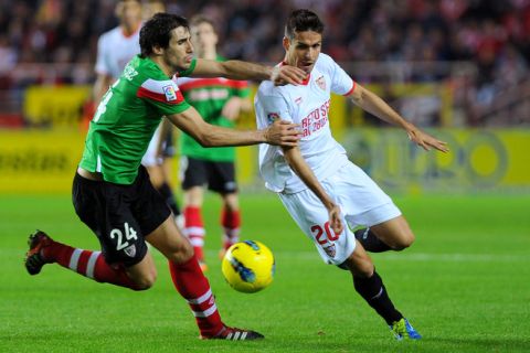 Athletic Bilbao's midfielder Javi Martinez (L) vies with Sevilla's defender Manuel del Moral (R) during the Spanish league football match between Sevilla CF and Athletic Bilbao at Ramon Sanchez Pizjuan stadium in Sevilla on November 20, 2011.    AFP PHOTO / JORGE GUERRERO (Photo credit should read Jorge Guerrero/AFP/Getty Images)