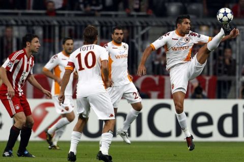 Bayern Munich's Dutch team captain Mark van Bommel (L) looks on as AS Roma's Marco Borriello (R) controls the ball during their Champions League Group E soccer match in Munich September 15, 2010.   REUTERS/Michaela Rehle (GERMANY - Tags: SPORT SOCCER)