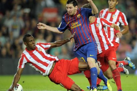 Barcelona's Argentinian forward Lionel Messi vies with Atletico Madrid's Colombian defender Luis Perea (L) during their Spanish League football match between FC Barcelona and Atletico de Madrid on September 24, 2011 at Camp Nou stadium in Barcelona. AFP PHOTO/LLUIS GENE (Photo credit should read LLUIS GENE/AFP/Getty Images)