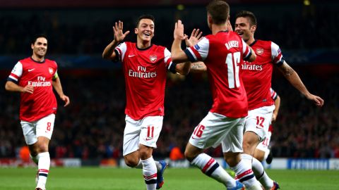 LONDON, ENGLAND - OCTOBER 01:  Mesut Oezil #11of Arsenal is congratulated by teammate Aaron Ramsey #16 after scoring the opening goal during UEFA Champions League Group F match between Arsenal FC and SSC Napoli at Emirates Stadium on October 1, 2013 in London, England.  (Photo by Paul Gilham/Getty Images)