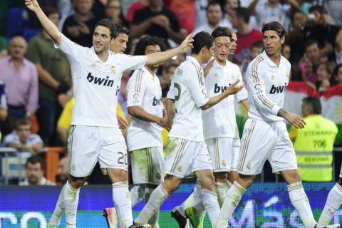 Real Madrid's Argentinian forward Gonzalo Higuain (L) celebrates after scoring his team's third goal during the Spanish League football match Real Madrid against Betis at the Santiago Bernabeu stadium in Madrid on October 15, 2011.   AFP PHOTO/JAVIER SORIANO (Photo credit should read JAVIER SORIANO/AFP/Getty Images)