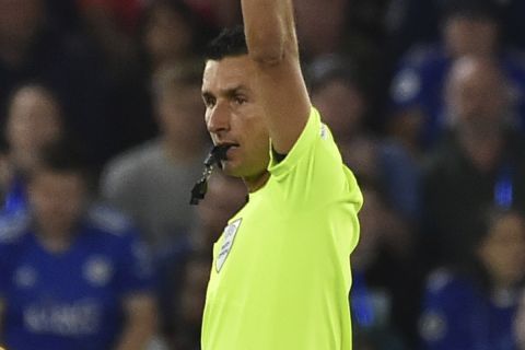 Referee Tiago Martins shows a yellow card to Napoli's Giovanni Di Lorenzo, left, during the Europa League Group C soccer match between Leicester City and Napoli at the King Power Stadium in Leicester, England, Thursday, Sept.16, 2021. (AP Photo/Rui Vieira)