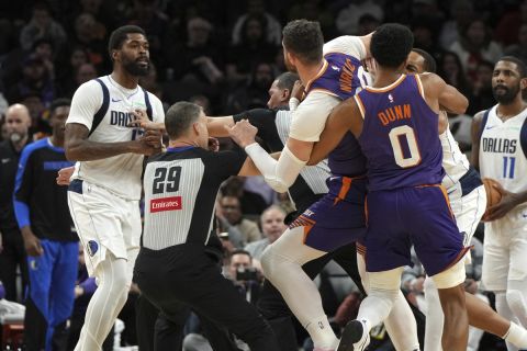 Naji Marshall, izquierda, de los Mavericks de Dallas y Jusuf Nurkic, de los Suns de Phoenix, tuvieron que ser separados después de un pleito durante la segunda mitad del juego de baloncesto de la NBA, el viernes 27 de diciembre de 2024, en Phoenix. Dallas ganó 98-89. (AP Foto/Rick Scuteri)