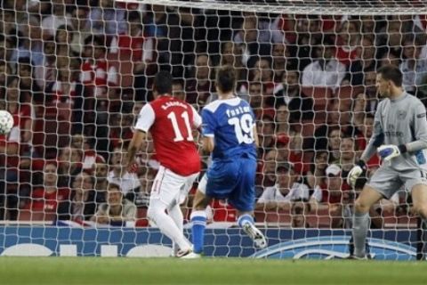 Arsenal's Wojciech Szczesny, right, watches the ball as Olympiakos' David Fuster, centre, scores during their Champions League group F soccer match at the Emirates stadium, London, Wednesday Sept. 28, 2011. (AP Photo/Kirsty Wigglesworth) 