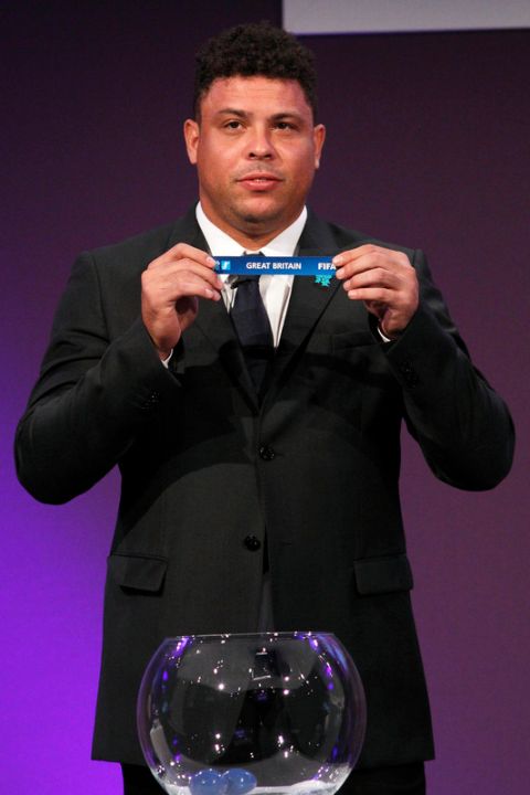 Former Brazilian footballer Ronaldo holds up Britain's paper during the draw for the London 2012 Olympic football tournament at Wembley Stadium in London, on April 24, 2012. Host nation Great Britain will kick off the Olympic football tournament against Senegal at Manchester United's Old Trafford ground on July 26 following the draw made at Wembley. AFP PHOTO / JUSTIN TALLIS (Photo credit should read JUSTIN TALLIS/AFP/Getty Images)