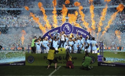 Manchester City players lift the English Premier League trophy after the soccer match between Manchester City and Huddersfield Town at Etihad stadium in Manchester, England, Sunday, May 6, 2018. (AP Photo/Rui Vieira)