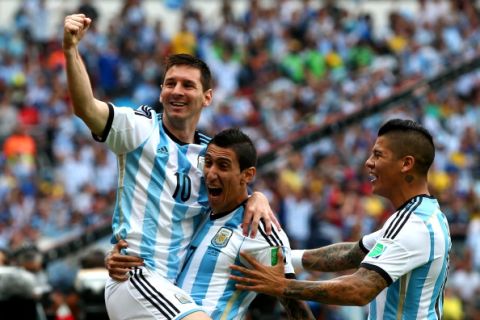 PORTO ALEGRE, BRAZIL - JUNE 25:  Lionel Messi (L) of Argentina celebrates scoring his team's first goal with his teammates Angel di Maria (C) and Marcos Rojo (R) during the 2014 FIFA World Cup Brazil Group F match between Nigeria and Argentina at Estadio Beira-Rio on June 25, 2014 in Porto Alegre, Brazil.  (Photo by Alex Grimm - FIFA/FIFA via Getty Images)