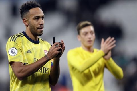 Arsenal's Pierre-Emerick Aubameyang, left, and Arsenal's Mesut Ozil applauds to supporters at the end of the English Premier League soccer match between West Ham Utd and Arsenal at the London Stadium in London, Monday, Dec. 9, 2019. (AP Photo/Kirsty Wigglesworth)