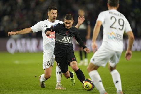 Angers' Thomas Mangani, left, challenges for the ball with PSG's Marco Verratti during the French League One soccer match between Paris Saint-Germain and Angers at the Parc des Princes in Paris, France, Friday, Oct. 15, 2021. (AP Photo/Francois Mori)