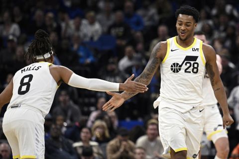 Utah Jazz forward Brice Sensabaugh (28) is congratulated by guard Patty Mills (8) after scoring during the second half of an NBA basketball game as Orlando Magic guard Jett Howard (13) walks up the court, Sunday, Jan. 5, 2025, in Orlando, Fla. (AP Photo/Phelan M. Ebenhack)