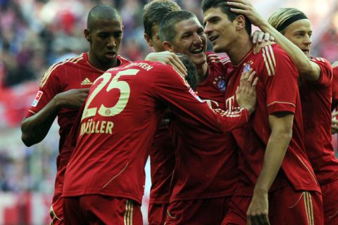 (L-R) Bayern Munich defender Jerome Boateng, striker Thomas Mueller, midfielder Bastian Schweinsteiger and striker Mario Gomez celebrate after the first goal for Munich during the German first division Bundesliga football match FC Bayern Munich vs Hertha BSC Berlin in the southern German city of Munich on October 15, 2011.  AFP PHOTO / CHRISTOF STACHE

RESTRICTIONS / EMBARGO - DFL LIMITS THE USE OF IMAGES ON THE INTERNET TO 15 PICTURES (NO VIDEO-LIKE SEQUENCES) DURING THE MATCH AND PROHIBITS MOBILE (MMS) USE DURING AND FURTHER TWO HOURS AFTER THE MATCH: FOR MORE INFORMATION CONTACT DFL. (Photo credit should read CHRISTOF STACHE/AFP/Getty Images)