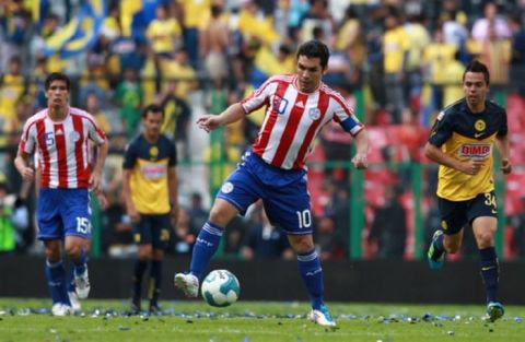 Soccer player Salvador Cabanas, front, playing for Paraguay's national soccer team, plays the ball during a game in his honor between Paraguay and America at the Azteca stadium in Mexico City, Wednesday, Aug. 10, 2011. Cabanas was shot in the head in January 2010 in Mexico City. (AP Photo/Christian Palma)