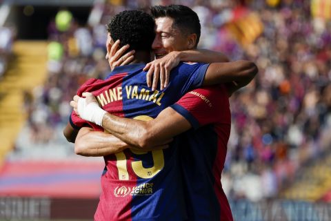 Barcelona's Robert Lewandowski, right, is congratulated after scoring his side's 2nd goal by Lamine Yamal during the Spanish La Liga soccer match between FC Barcelona and Valladolid at the Olympic stadium in Barcelona, Spain, Saturday, Aug. 31, 2024. (AP Photo/Joan Monfort)