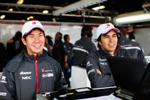 MELBOURNE, AUSTRALIA - MARCH 25:  Kamui Kobayashi of Japan and Sauber F1 and team mate Sergio Perez of Mexico are seen in their team garage during practice for the Australian Formula One Grand Prix at the Albert Park Circuit on March 25, 2011 in Melbourne, Australia.  (Photo by Mark Thompson/Getty Images)