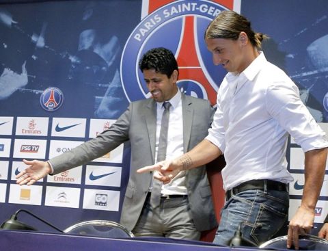 PSG President Nasser al-Khelaifi, left, of Qatar, shows the way to AC Milan striker Zlatan Ibrahimovic, of Sweden, at the Parc des Princes stadium in Paris, Wednesday, July 18, 2012 after signing an agreement with the Paris Saint Germain (PSG) club. Ibrahimovic will be the Ligue 1 club's third major signing of the summer, following the arrivals of former AC Milan teammate Thiago Silva and Napoli's Ezequiel Lavezzi. (AP Photo/Jacques Brinon)