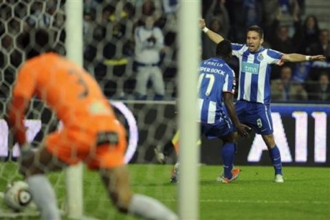 FC Porto's Silvestre Varela, centre, reacts with Joao Moutinho after scoring the opening goal against Rio Ave's goalkeeper Paulo Santos, left, in a Portuguese League soccer match at the Dragao Stadium in Porto, Portugal, Sunday, Feb. 6, 2011. (AP Photo/Paulo Duarte)