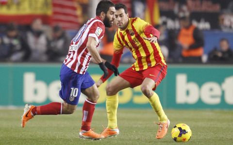 Partido de la Liga BBVA disputado entre el Atlético y el Barcelona. En la imagen, Arda y Busquets. 

League BBVA match played between Atlético and Barcelona. In this picture, Arda and Busquets.