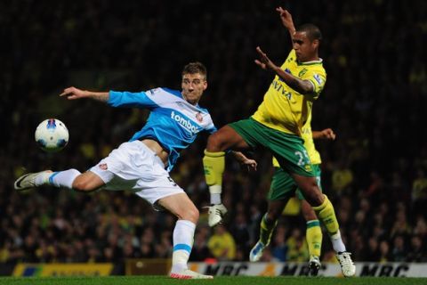 NORWICH, ENGLAND - SEPTEMBER 26:  Nicklas Bendtner of Sunderland shoots under pressure from Kyle Naughton of Norwich City during the Barclays Premier League match between Norwich City and Sunderland at Carrow Road on September 26, 2011 in Norwich, England.  (Photo by Jamie McDonald/Getty Images)