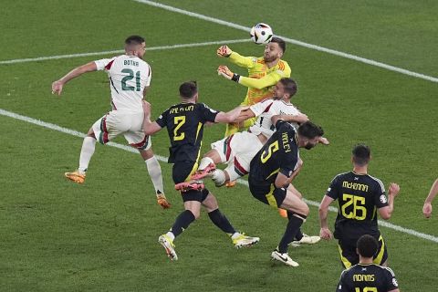 Hungary's Barnabas Varga, bottom center, collides with Scotland's goalkeeper Angus Gunn, top center, during a Group A match between Scotland and Hungary at the Euro 2024 soccer tournament in Stuttgart, Germany, Sunday, June 23, 2024. (AP Photo/Ariel Schalit)