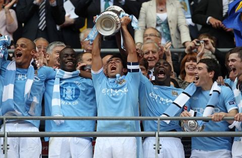 Manchester City's Argentinian footballer Carlos Tevez (C) celebrates with the FA Cup after beating Stoke 1-0 during the FA Cup final football match between Manchester City and Stoke City at Wembley Stadium in London, on May 14, 2011. AFP PHOTO / ADRIAN DENNIS
NOT FOR MARKETING OR ADVERTISING USE/RESTRICTED TO EDITORIAL USE (Photo credit should read ADRIAN DENNIS/AFP/Getty Images)