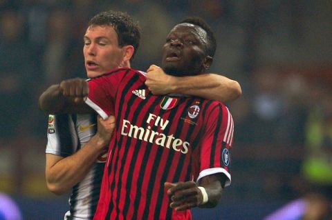 Juventus' Swiss defender Stephan Lichtseiner (L) holds AC Milan midfielder Sulley Ali Muntari of Ghana on February 25, 2012 during a Serie A football match at the San Siro stadium in Milan. AFP PHOTO / GIUSEPPE CACACE (Photo credit should read GIUSEPPE CACACE/AFP/Getty Images)