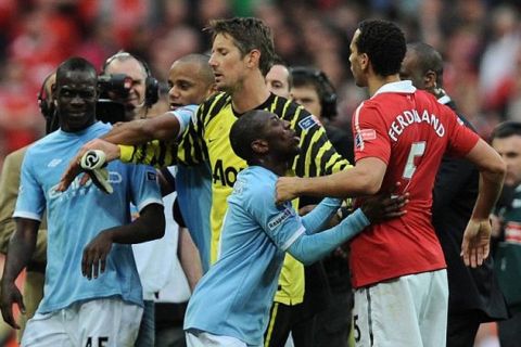 Mario Balotelli of Manchester City winks at Rio Ferdinand of Manchester United after a full time melee